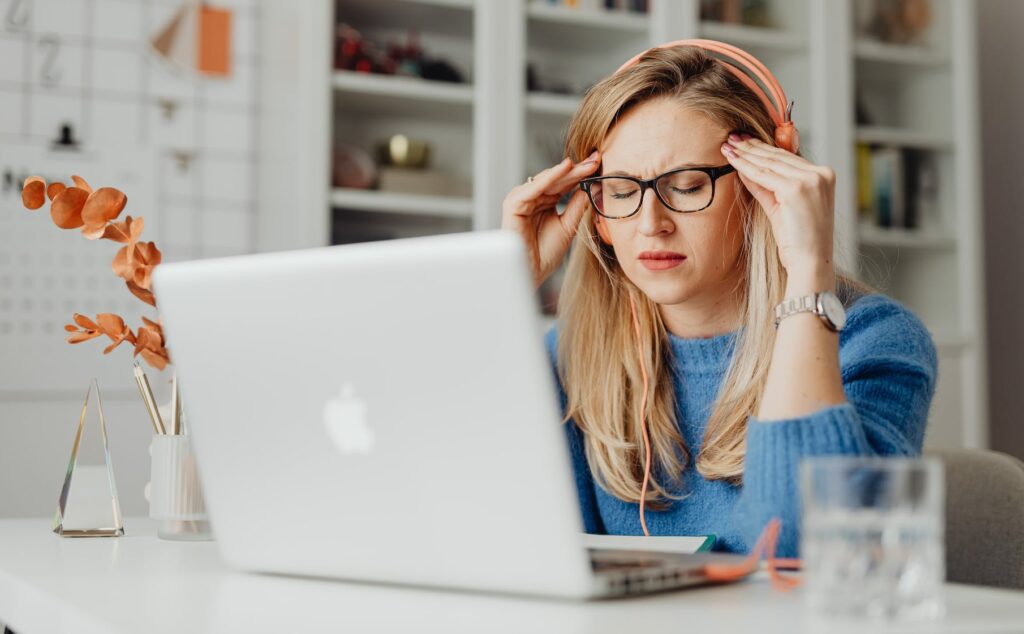 woman in blue shirt using macbook