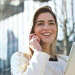 woman in white blazer holding tablet computer