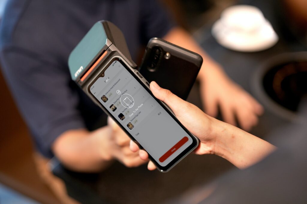 a person holding a payment terminal