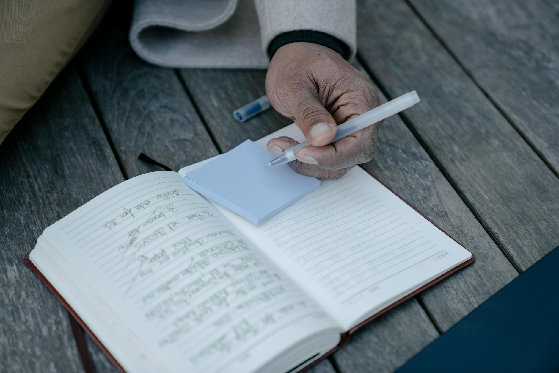 person writing on a sticky note