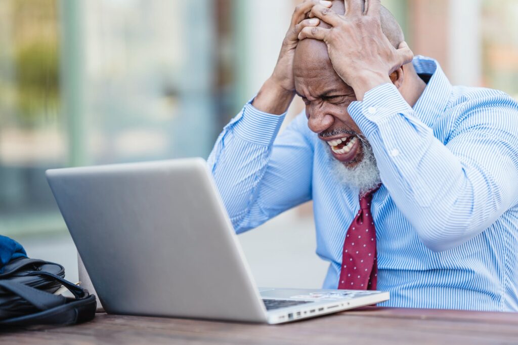 frustrated man in front of a laptop