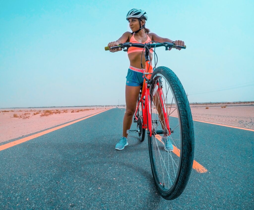 woman riding red mountain bike on asphalt road