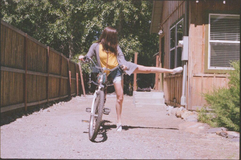woman wearing grey cardigan holding bike