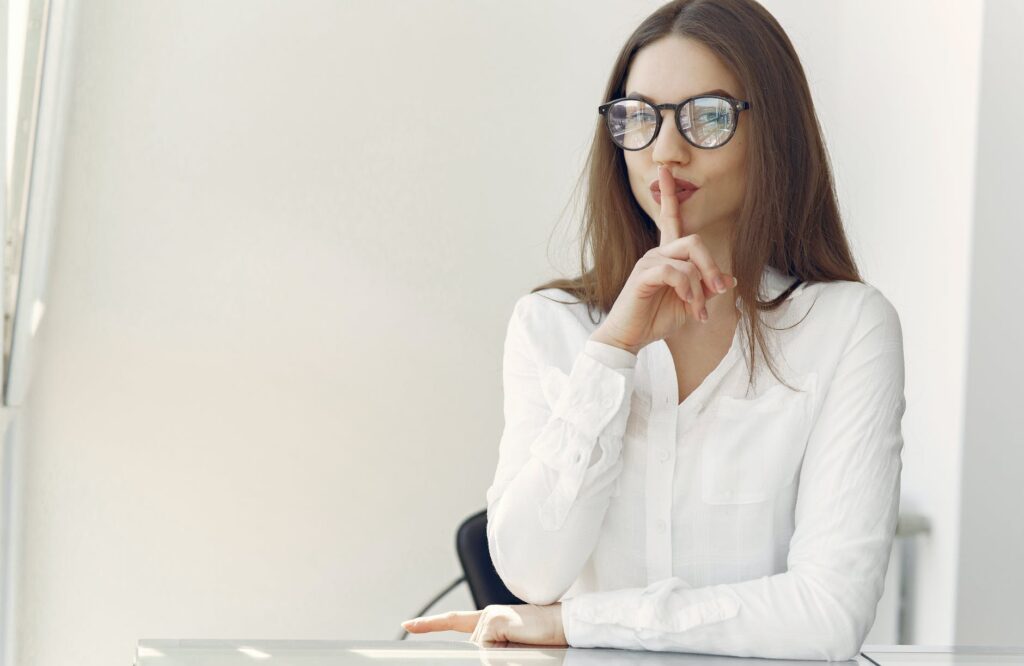 flirty young lady asking to keep secret sitting in office