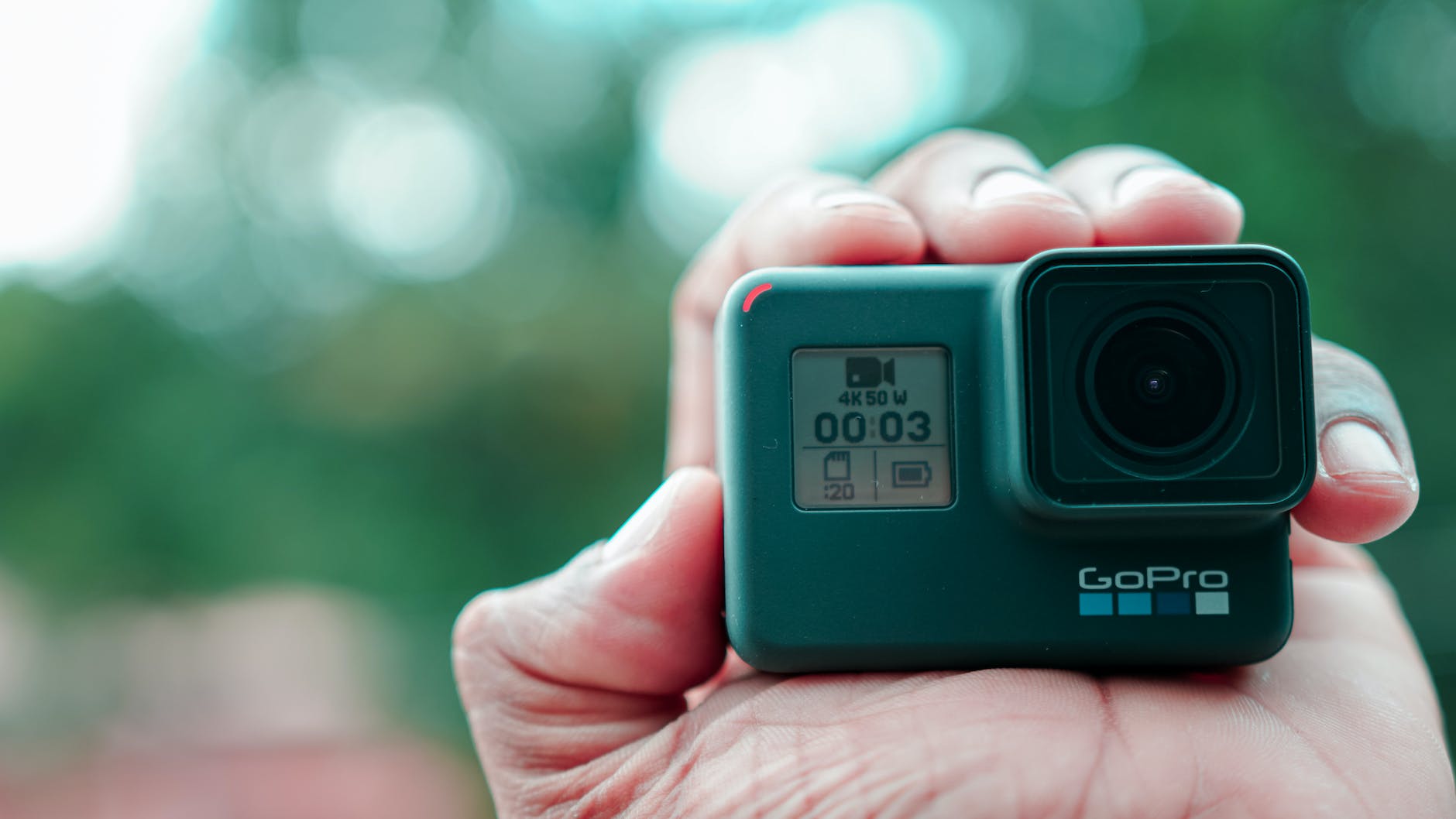 a close up shot of a person holding a gopro camera