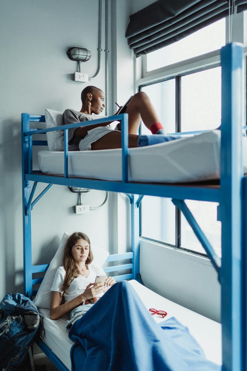 two women lying on blue bunk bed