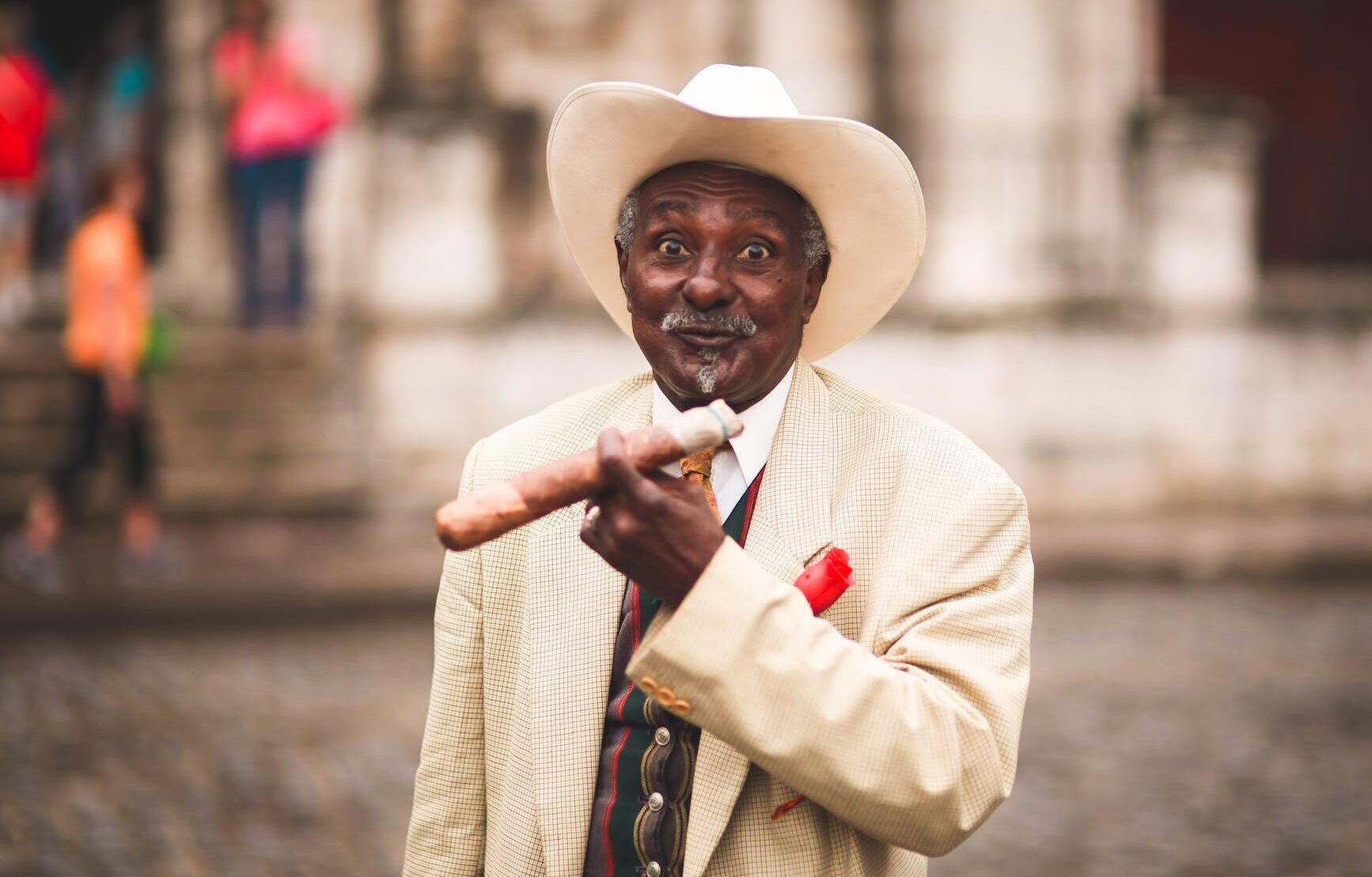 elderly ethnic man with cigar on the street