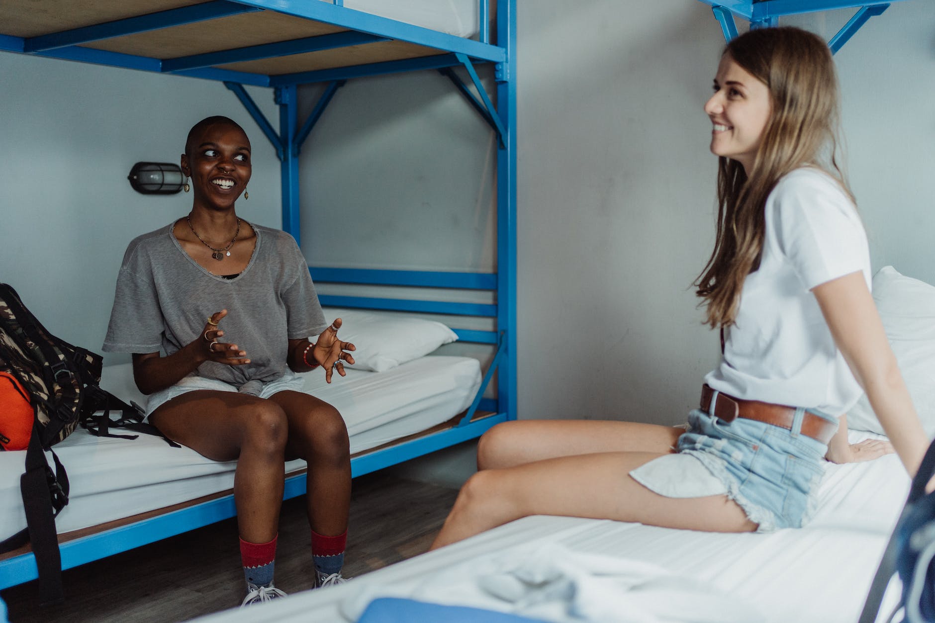 women sitting on bunk bed and smiling