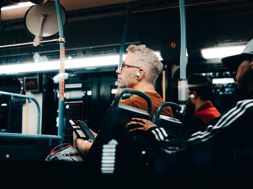 man with earphones riding on bus