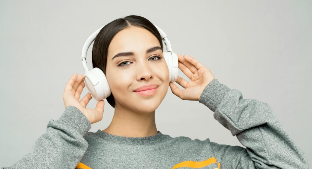 woman holding white headphones