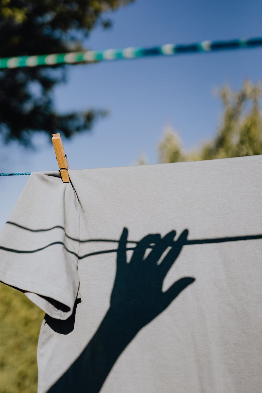 crop shadow of hand hanging linen on ropes