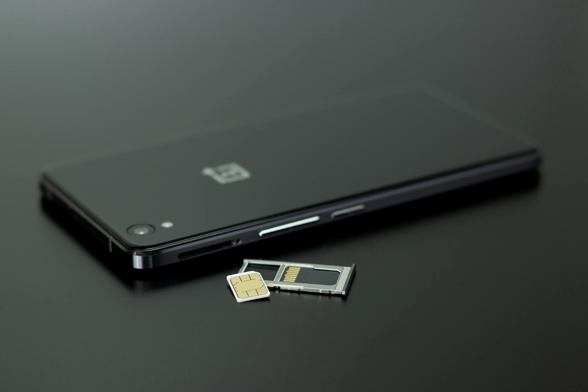 black smartphone on black table top