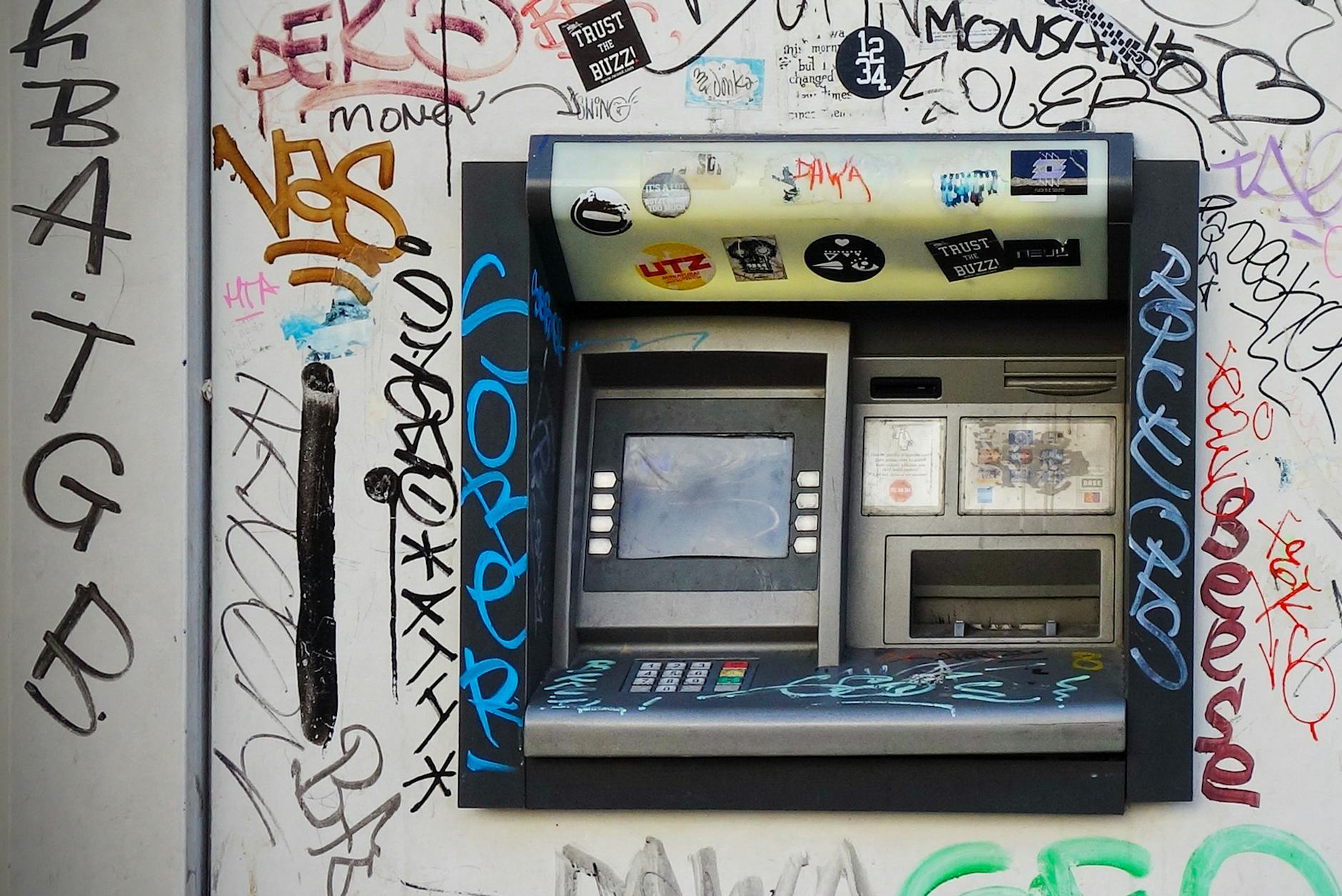 gray atm machine with graffiti